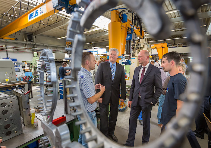 Fertigungsleiter Oliver Meinberg (l) zeigt dem Hauptgeschäftsführer der Handwerkskammer Erfurt Thomas Malcherek (2vl) und Wirtschaftsminister Wolfgang Tiefensee (2vr, SPD) und dem Azubi Timo Kubik am 15.07.2015 bei der DMF Werkzeugbau GmbH in Nohra die Produktion.