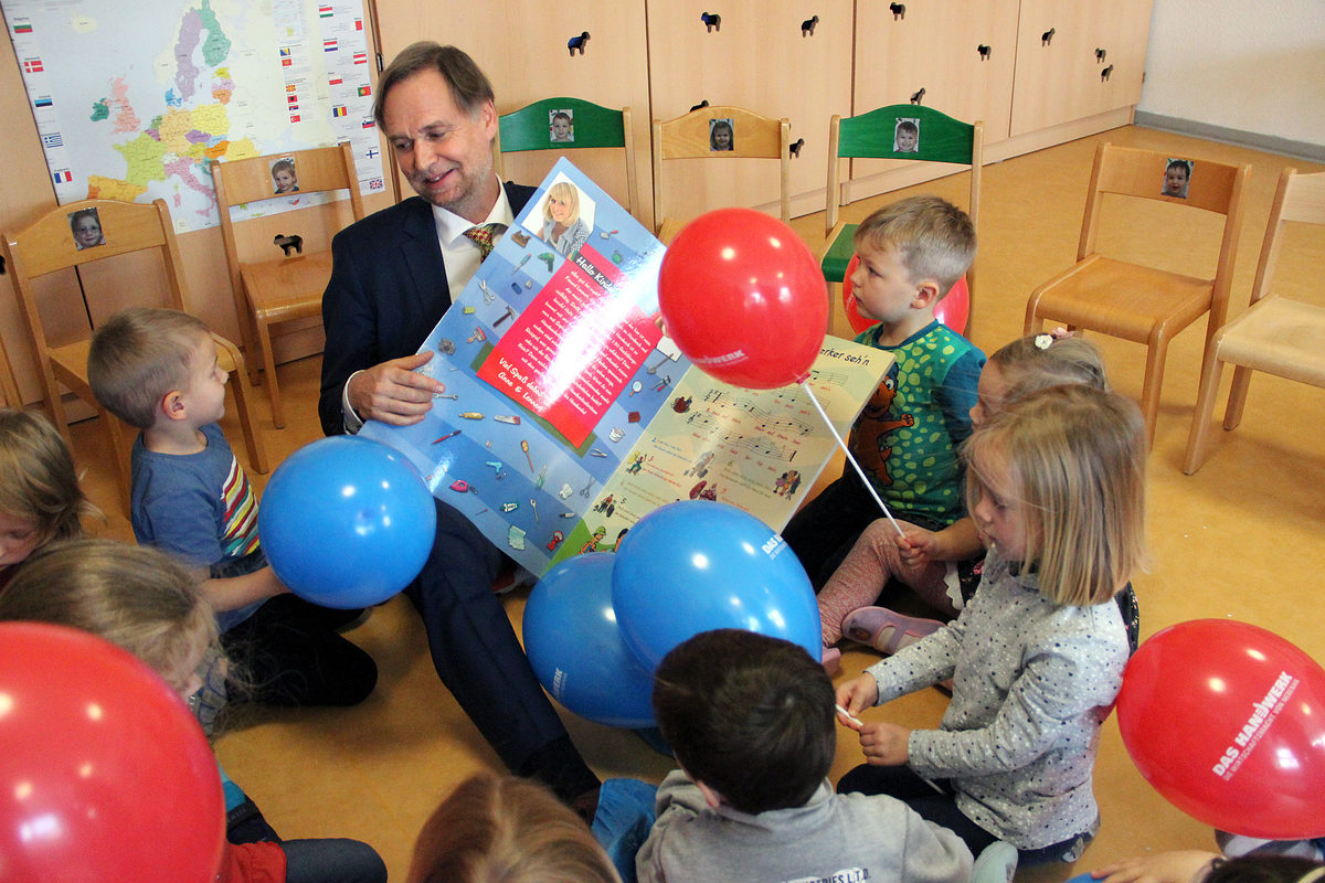 Handwerkskammer-Präsident Stefan Lobenstein singt mit den Kindern das Handwerker-Lied