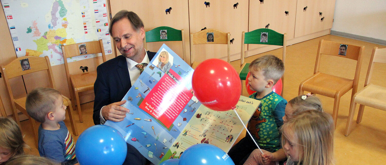 Handwerkskammer-Präsident Stefan Lobenstein singt mit den Kindern das Handwerker-Lied 