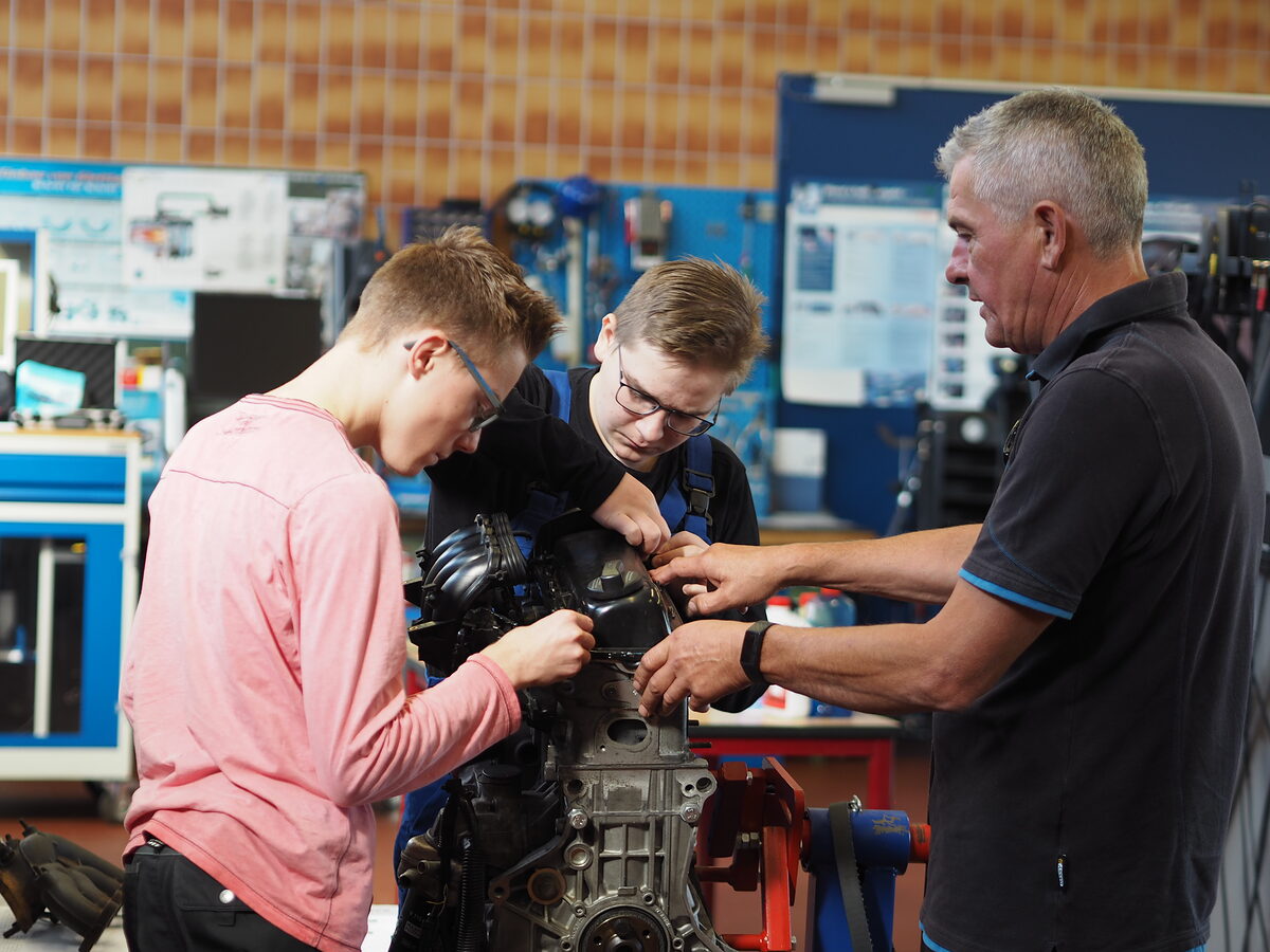Kfz-Ausbilder Steffen Kämmerer erklärt den Schülern den Aufbau eines Motors.